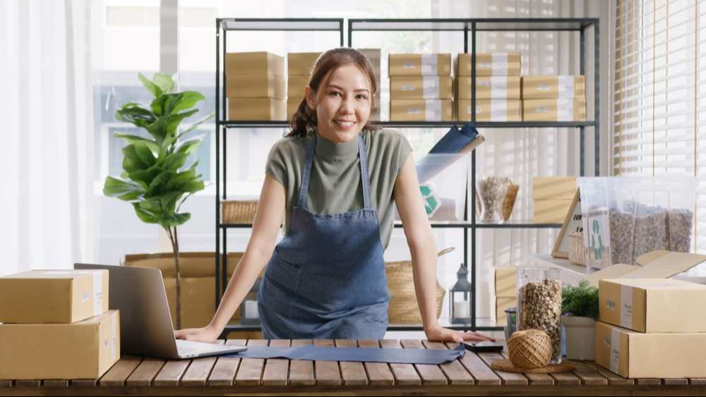 La vendeuse éco-responsable utilise des emballages écologiques en carton dans un magasin sans déchets à bilan carbone neutre. La vendeuse éco-responsable utilise des emballages écologiques en carton dans un magasin sans déchets à bilan carbone neutre.